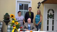 Auf dem Bild neben dem Jubilar seine Personenbetreuerin Frau Catalina-Florina C. aus Rumänien, unsere Gebietsleiterin Frau Elisabeth Alves und unser stellv. Geschäftsführer Herr Thomas Weinbörmair.